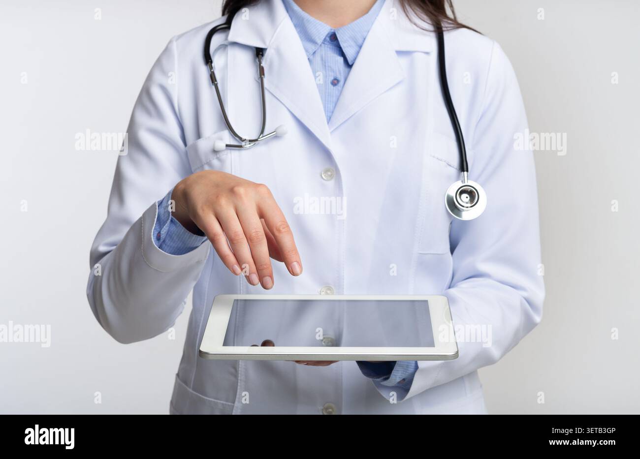 Unrecognizable Doctor Using Tablet Computer, White Background, Cropped Stock Photo