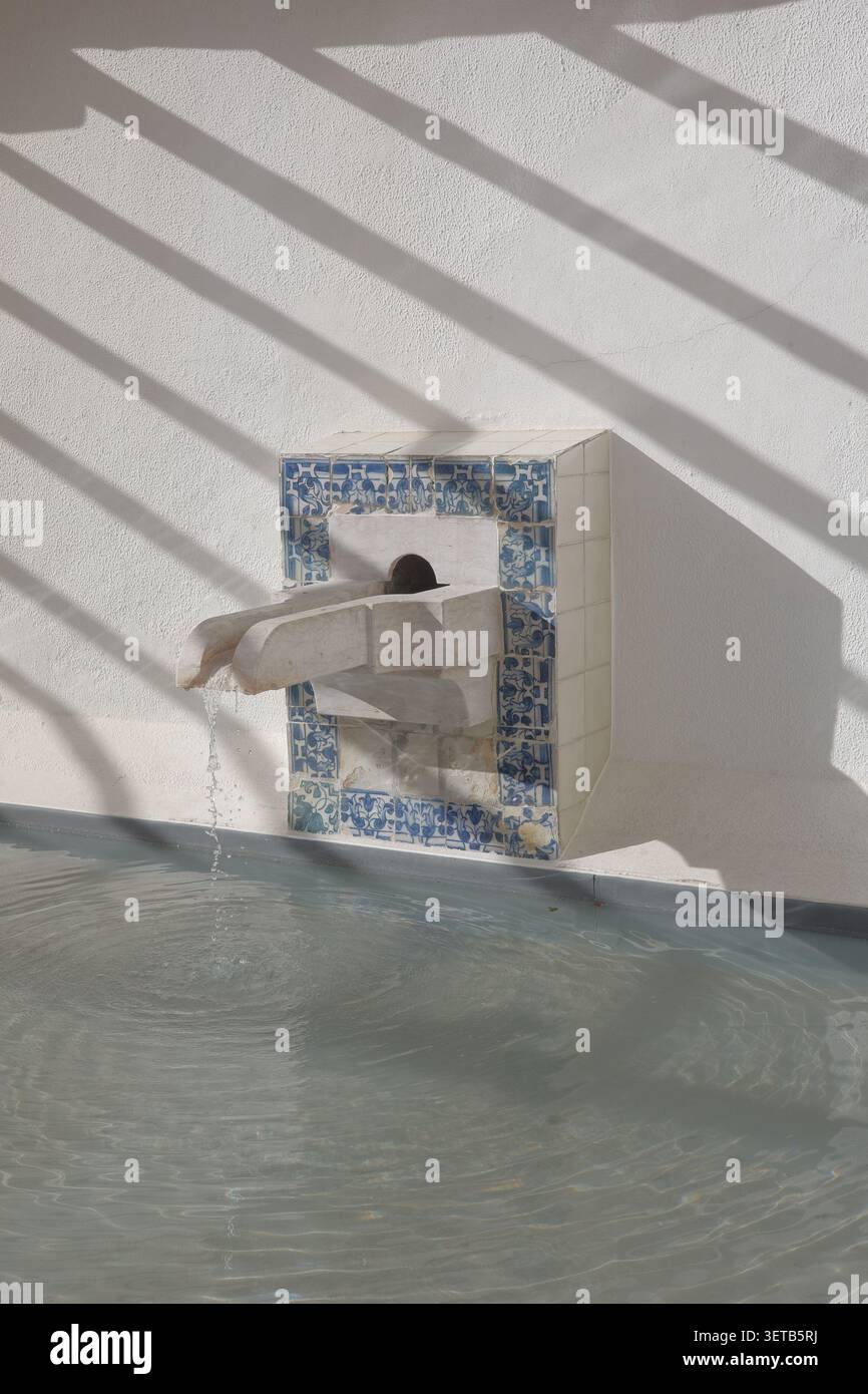 Damaged Azulejo Tile Border on Whitewashed Wall with Diagonal Shadow Pattern, Lisbon Stock Photo