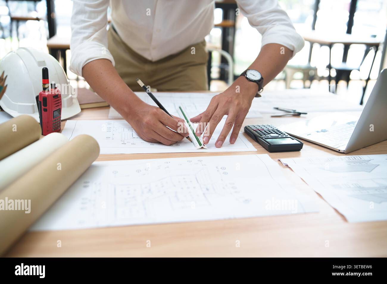 Engineer Drafting Plans at Desk in Construction Office Stock Photo