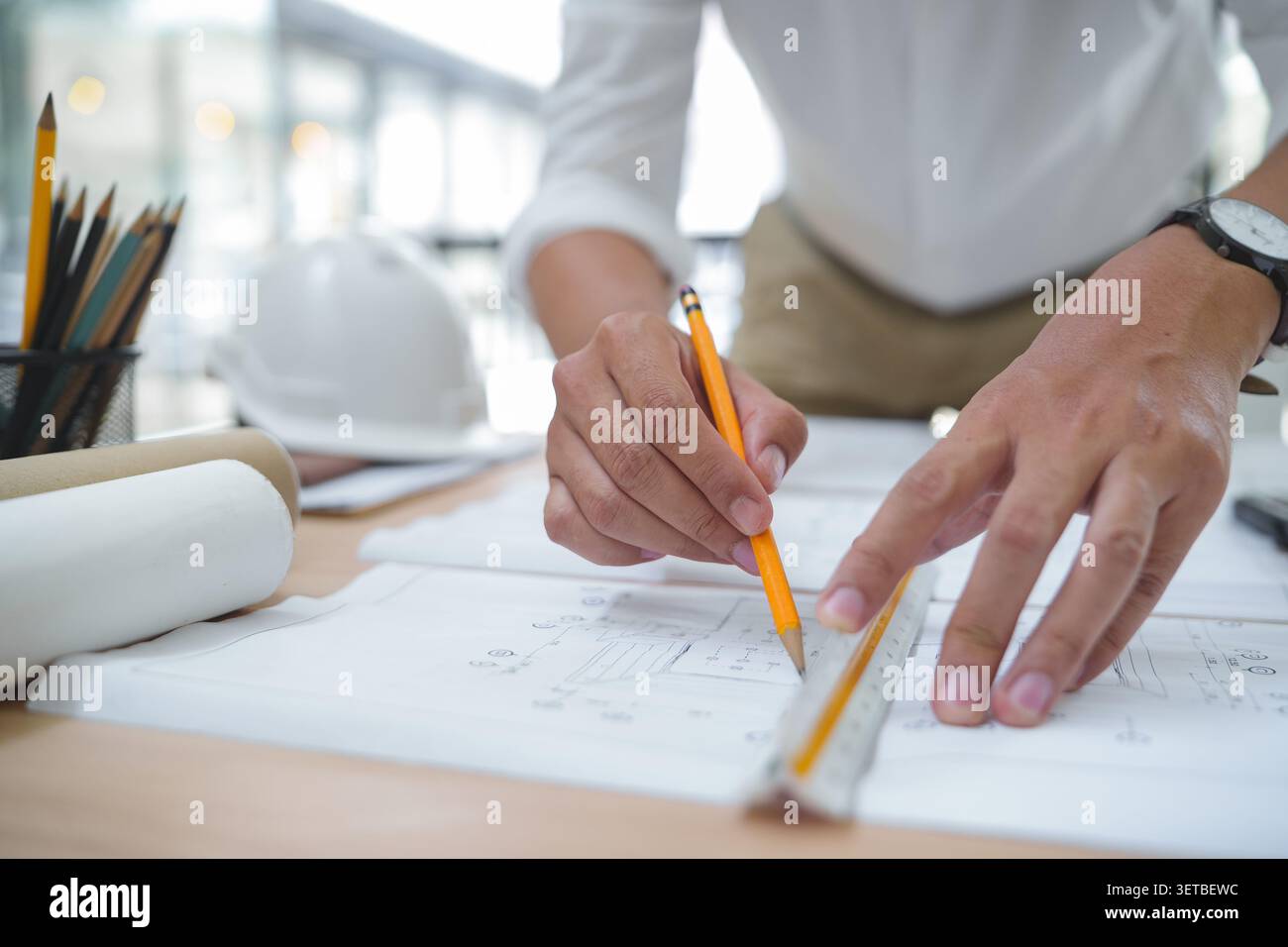 Architect or Engineer Working on Construction Plans in Office En Stock Photo