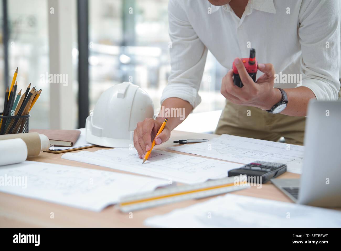 Engineer Reviewing Construction Plans with Tools and Documentati Stock Photo