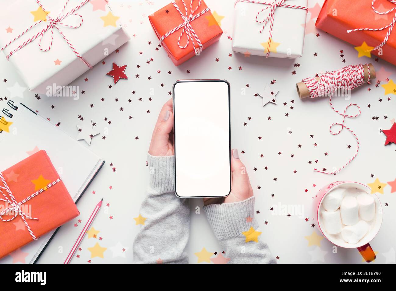 Modern cellphone with white blank screen in woman hands Stock Photo