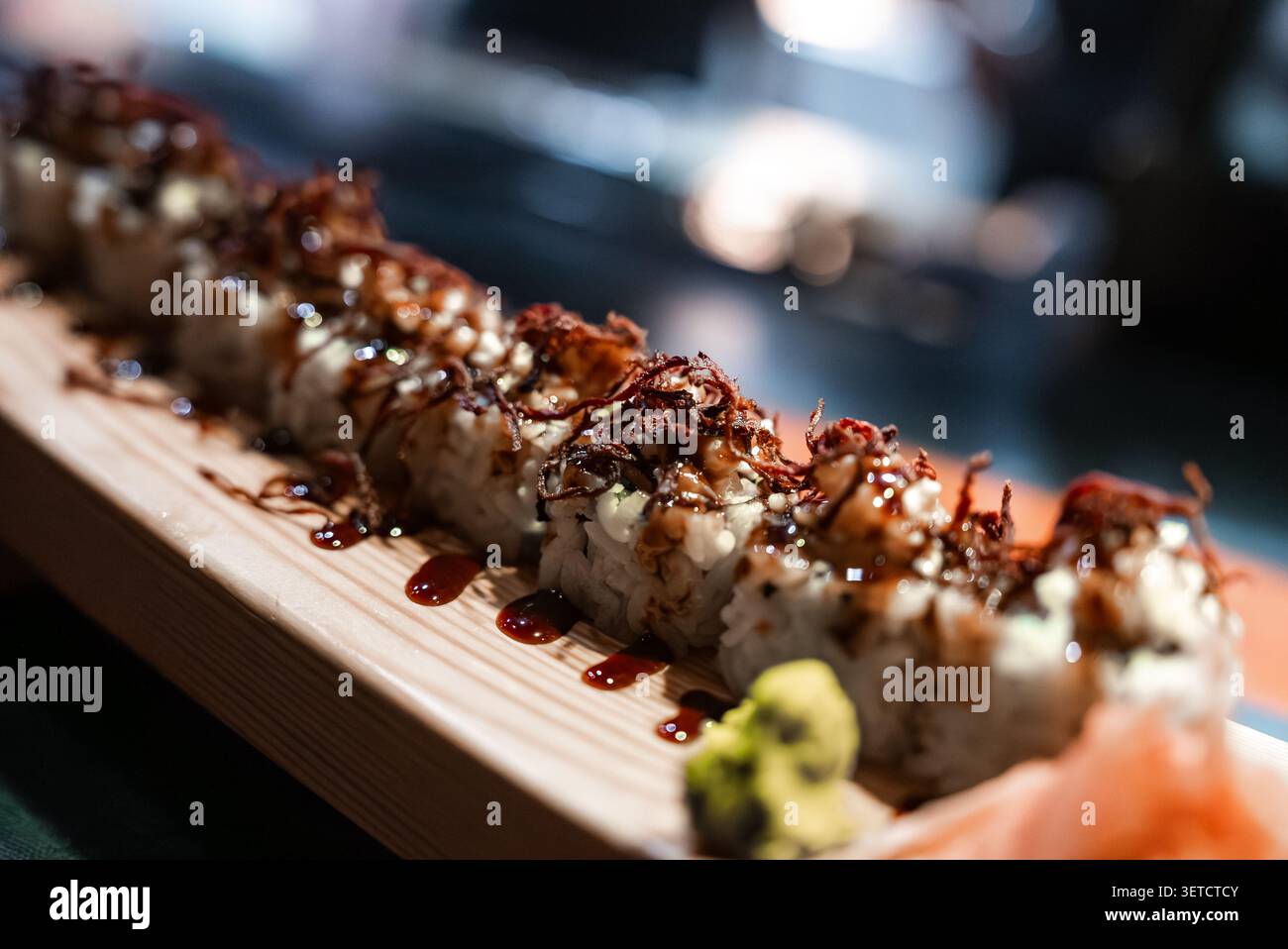 Sushi rolls on wooden platter with sauce in Maldives resort dining Stock Photo
