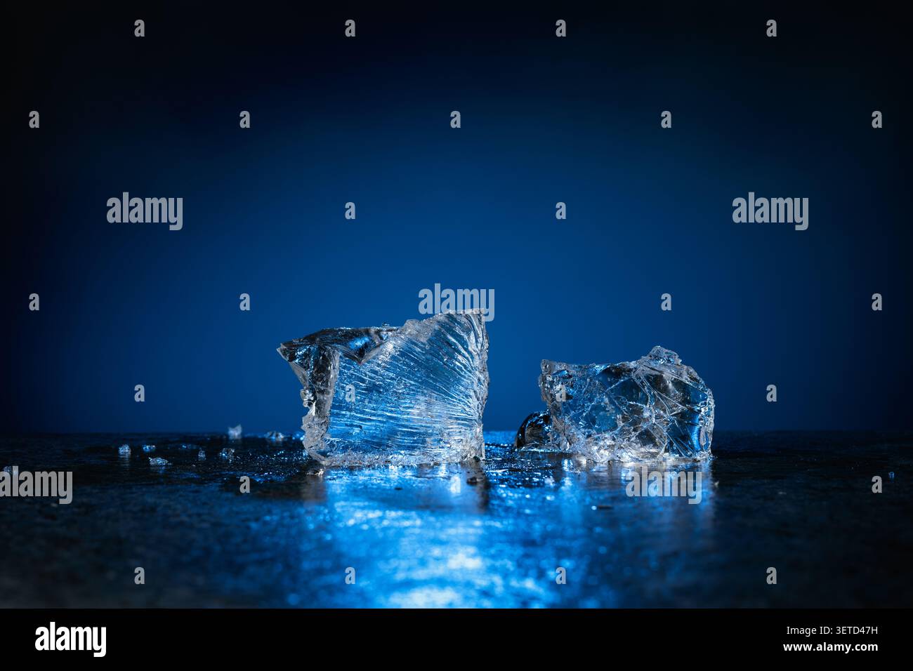 Broken ice with blue backlight on a dark background. Copy space. Stock Photo