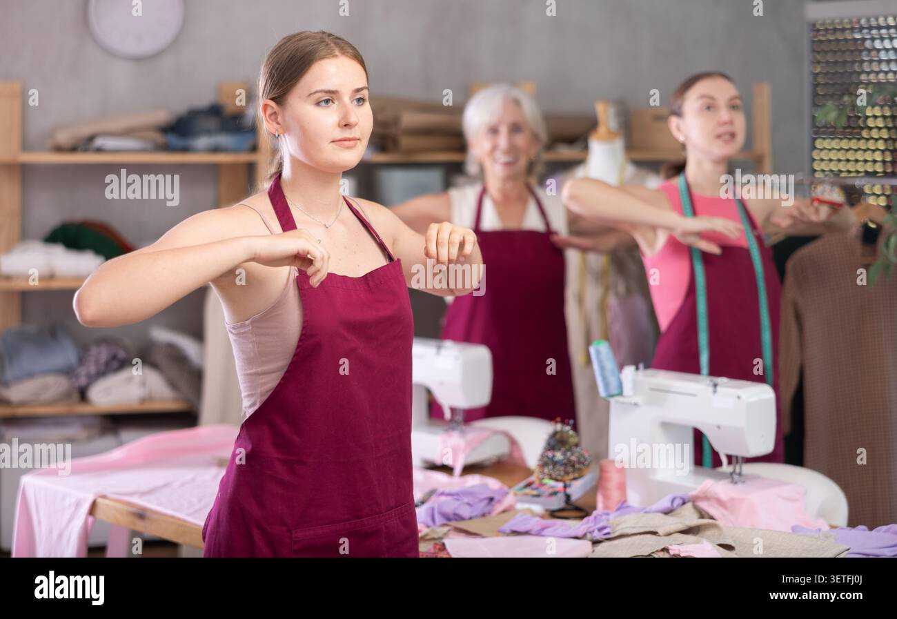 team of dressmakers doing a warm-up in the workshop Stock Photo