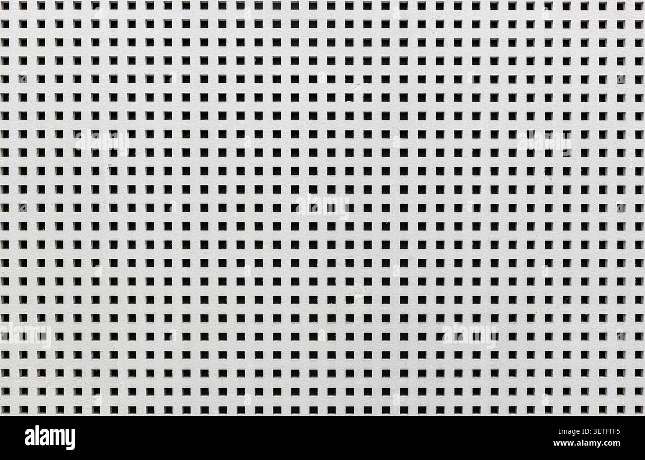 Perforated ceiling or wall panel texture with a uniform square holes pattern. Stock Photo