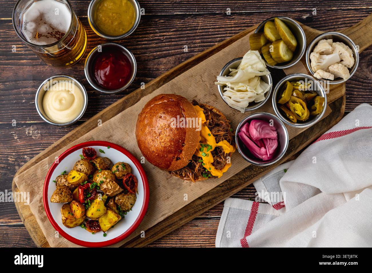 Slow cooked pulled rib beef burger with melted cheese and sides Stock Photo