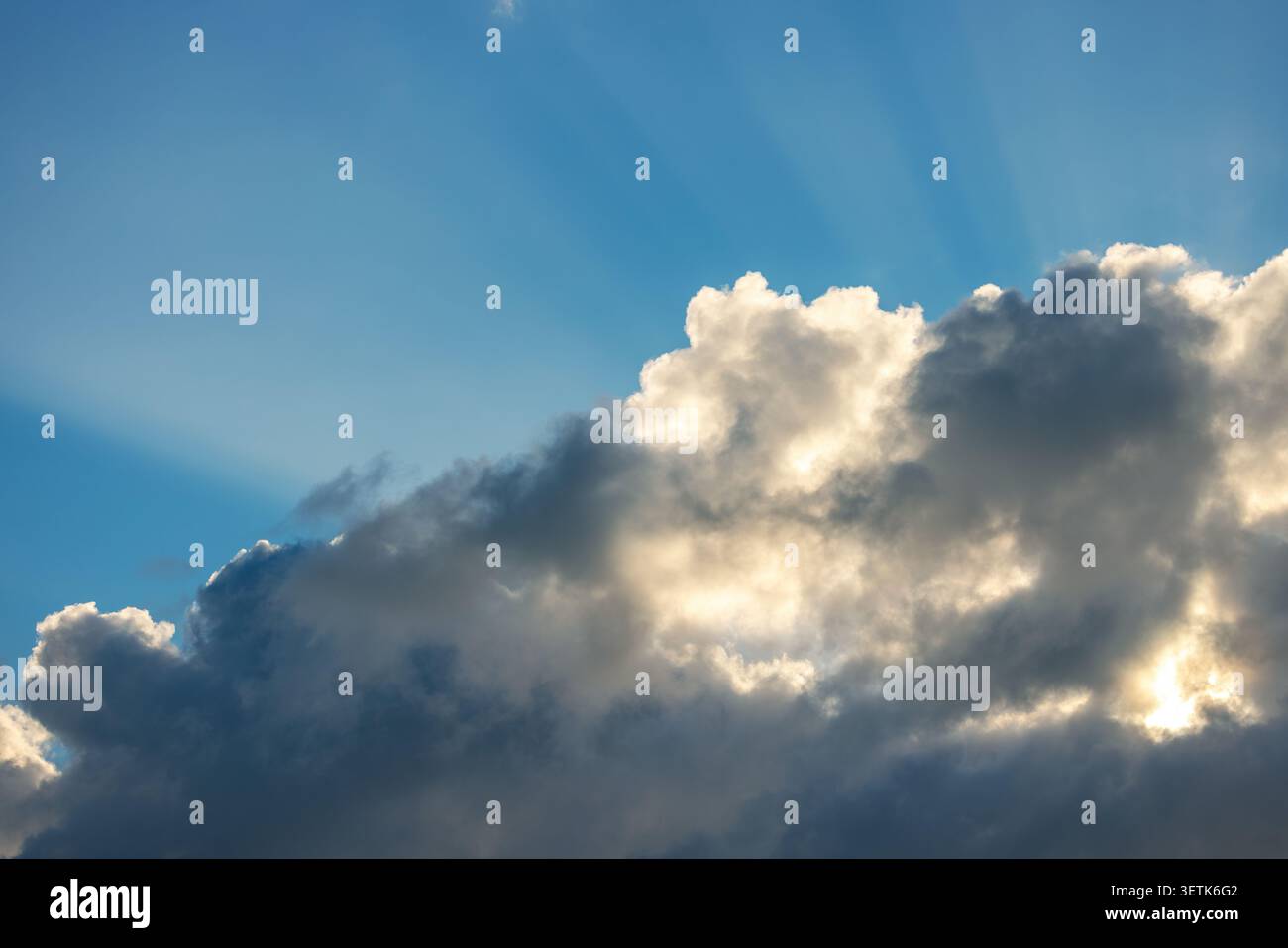 Sun rays breaking through clouds in blue sky over Punta Cana resort Stock Photo