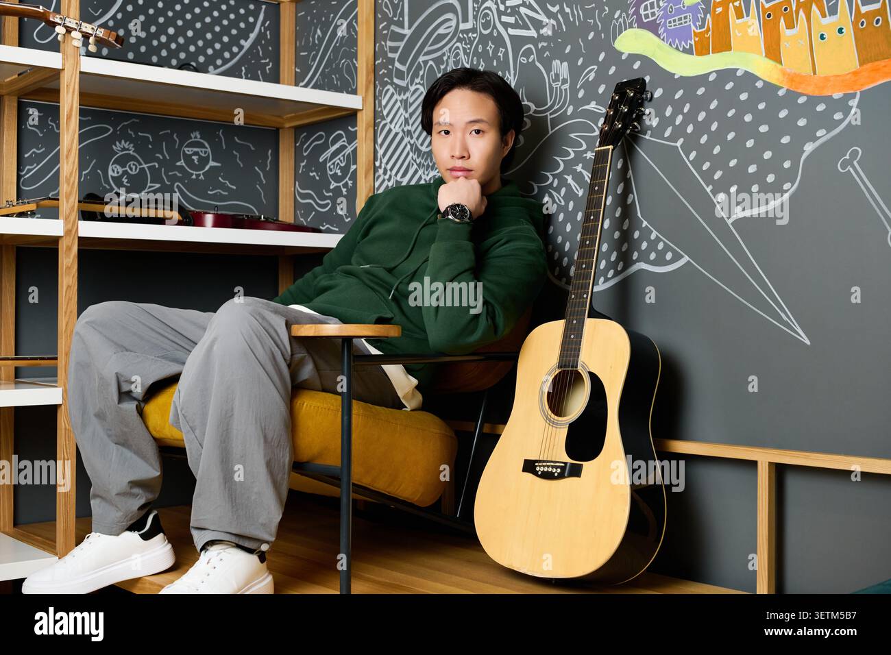 Casual attire highlights the young mans focus while he works in the creative space. Stock Photo