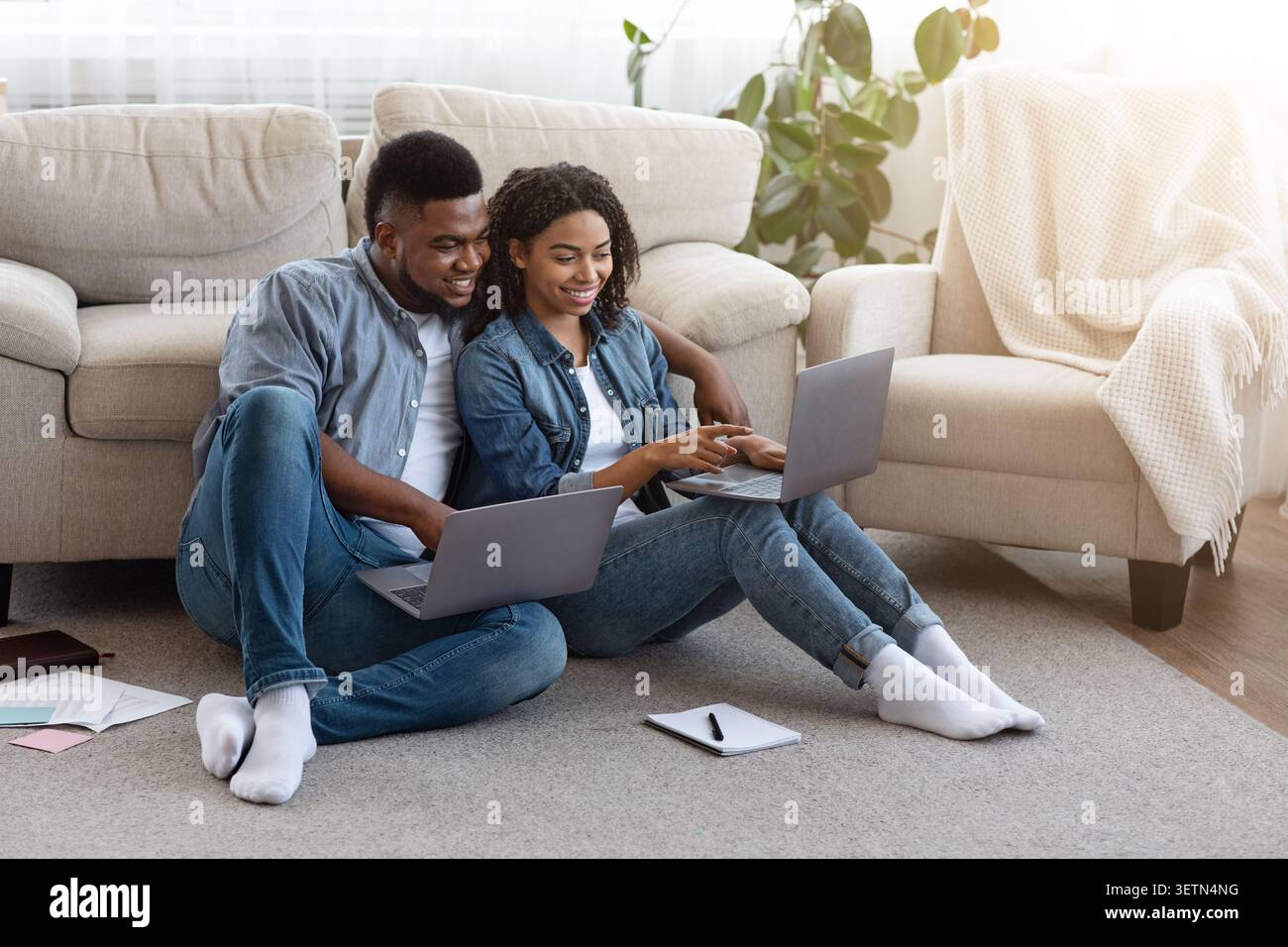 Remote Work. Black Couple Using Laptops At Home, Working Online Together Stock Photo