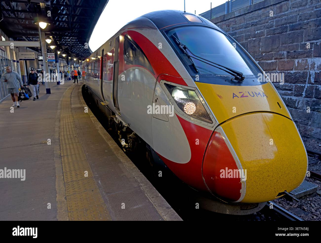 LNER Azuma train at Dundee station platform in the evening, illustrating Scottish intercity rail travel and well-lit night journeys Stock Photo