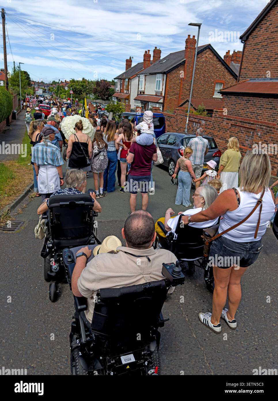 Wheelchair users and families join Grappenhall Walking Day procession in Albert Rd, Warrington, Cheshire, England, UK. Stock Photo