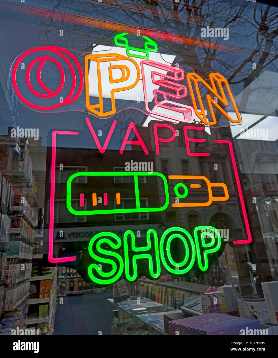 Illuminated vape shop window sign promoting e-cigarettes and modern vaping culture in a British town or city centre Stock Photo