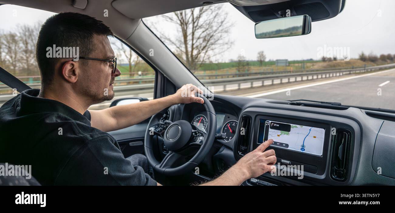 Man touching dashboard navigation screen while driving Stock Photo