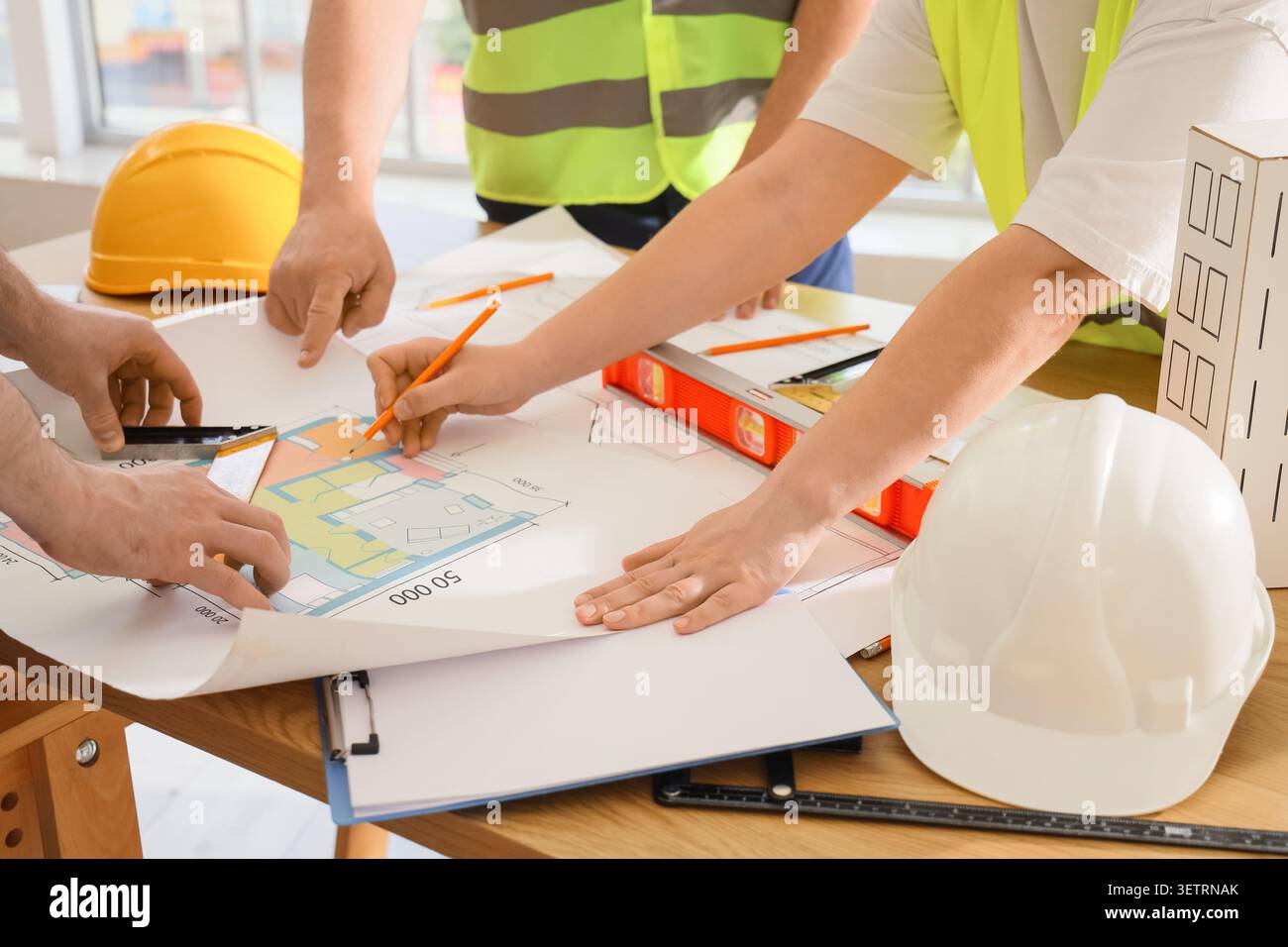 Architects collaborating on building blueprint Stock Photo
