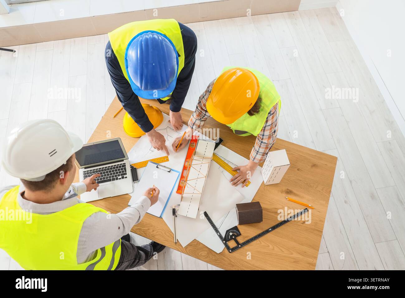 Construction workers collaborating on building plans Stock Photo