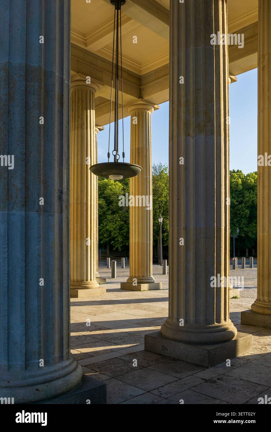 View through the side colonnade of the Brandenburg Gate in Berlin, Germany. Doric columns, Brandenburger Tor, dorische Säulen, vertical. Stock Photo