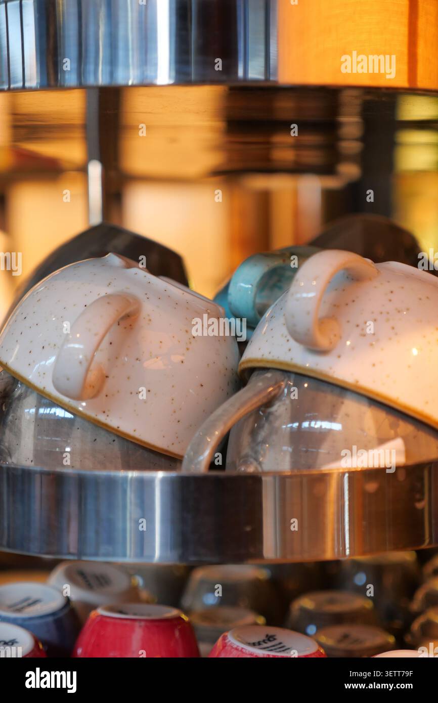 Cups stacked on a shelf in a kitchen area Stock Photo
