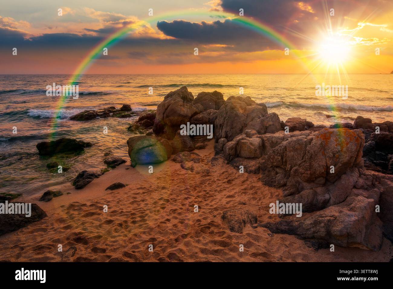 sunset over huge stones on a sandy beach. wonderful summer vacation season at the black sea. calm waves washing the sand shore. nature background with Stock Photo