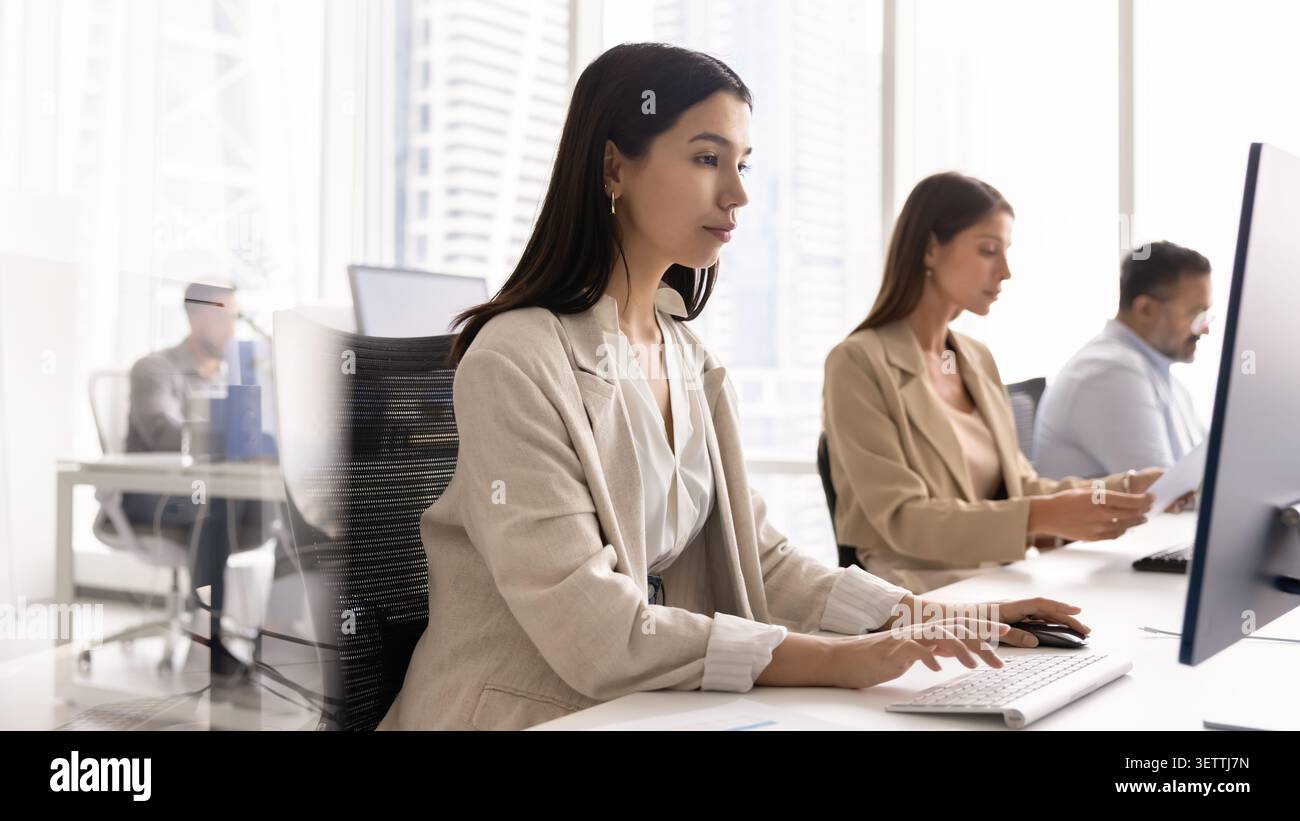 Asian office manager, customer support services employee working on computer Stock Photo