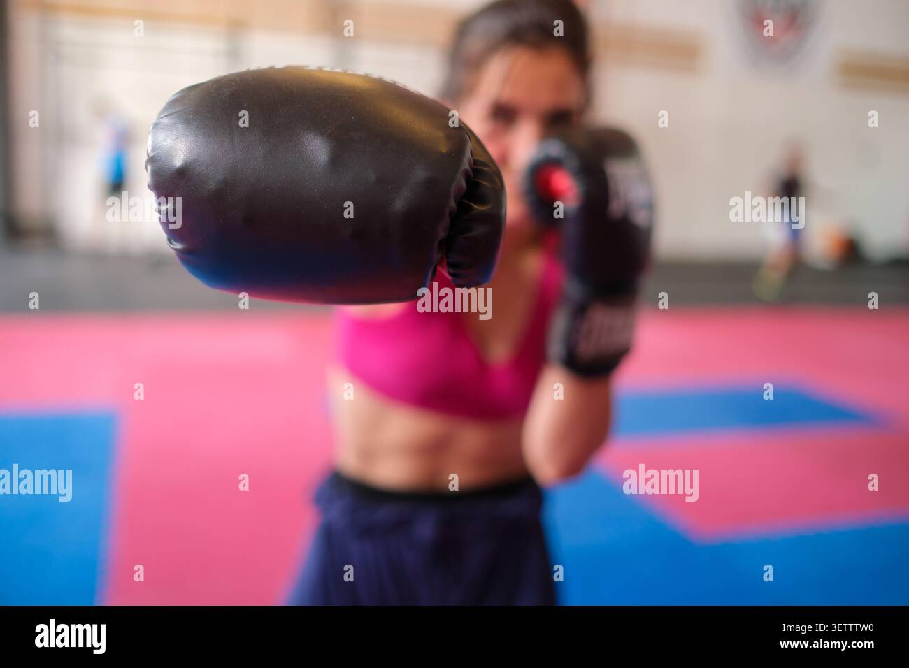 Woman boxer punching during intensely focused training session Stock Photo