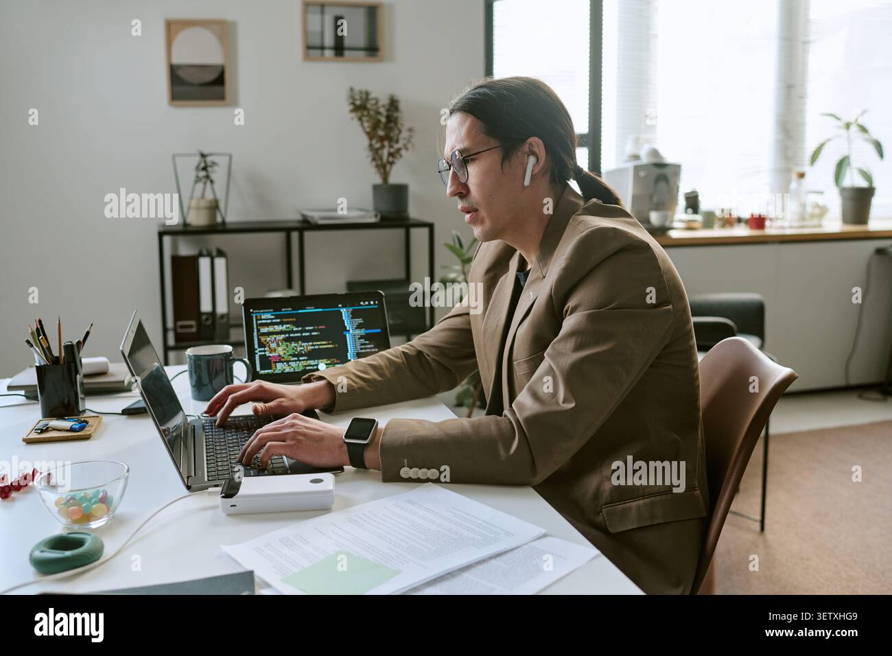 Asian Man Coding on Laptop in Office Stock Photo