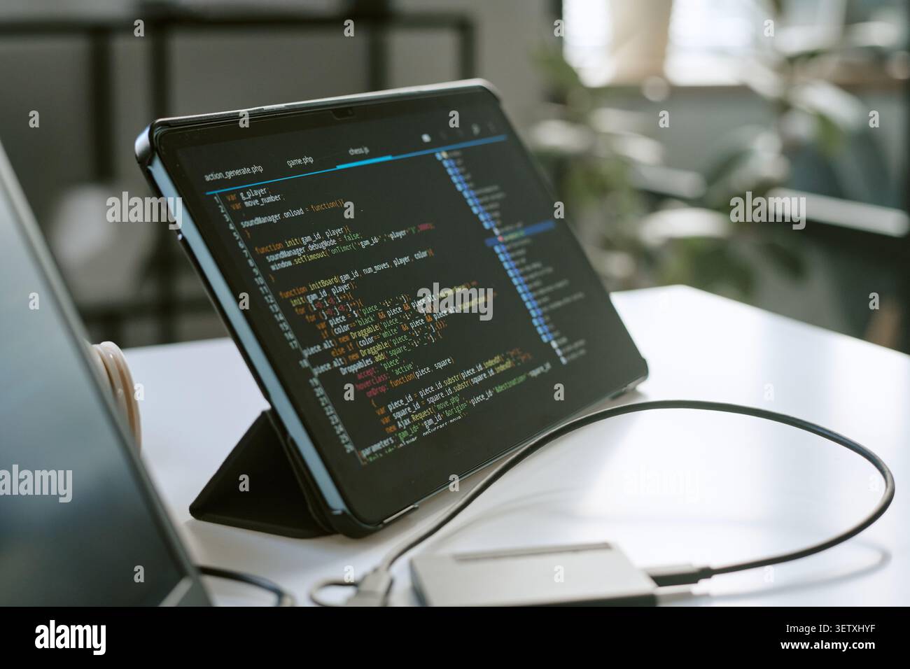 Tablet Displaying Software Code for App Development Workspace Stock Photo