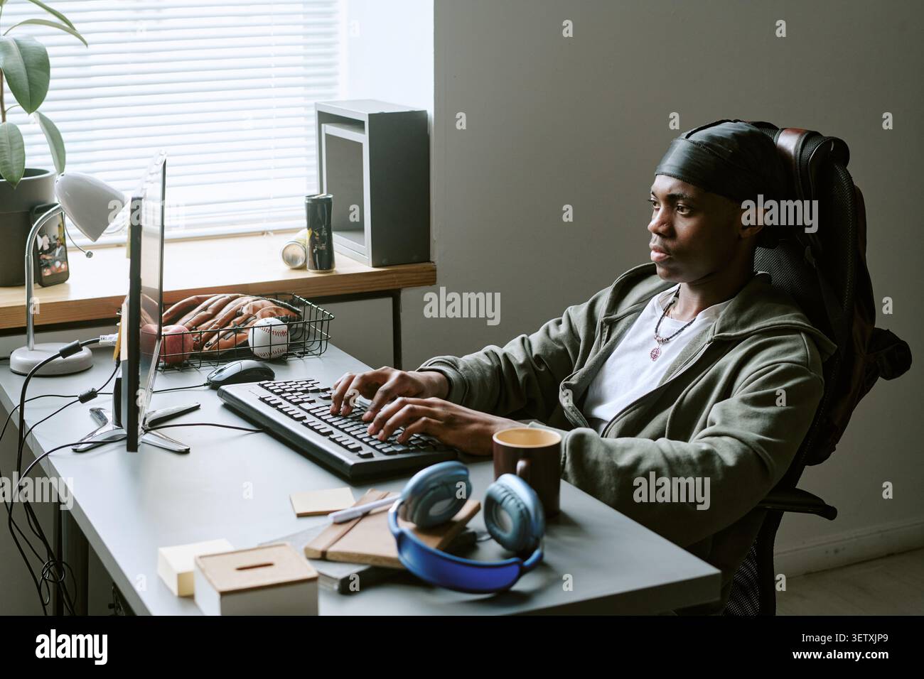 Black Man Typing at Desktop Computer in Office Stock Photo