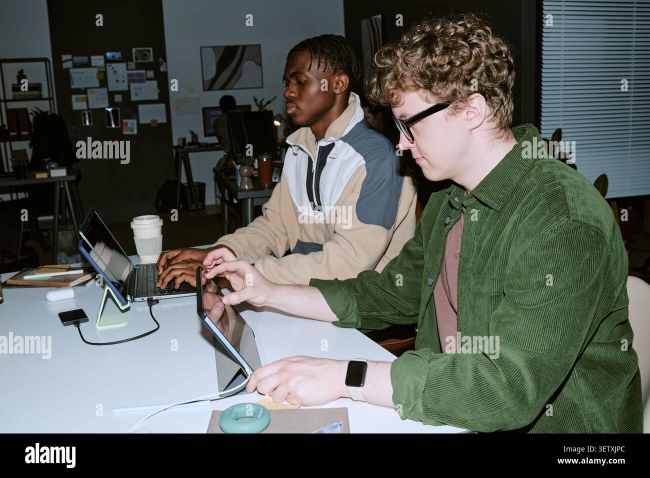 Multiethnic Men Working on Digital Devices in Modern Office Stock Photo