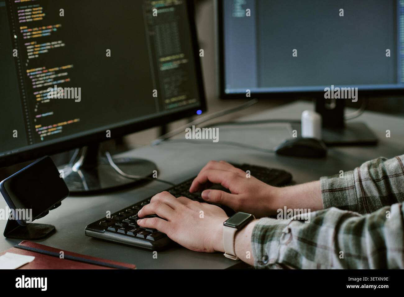Adult Man Coding at Dual Monitors for Software Development Stock Photo