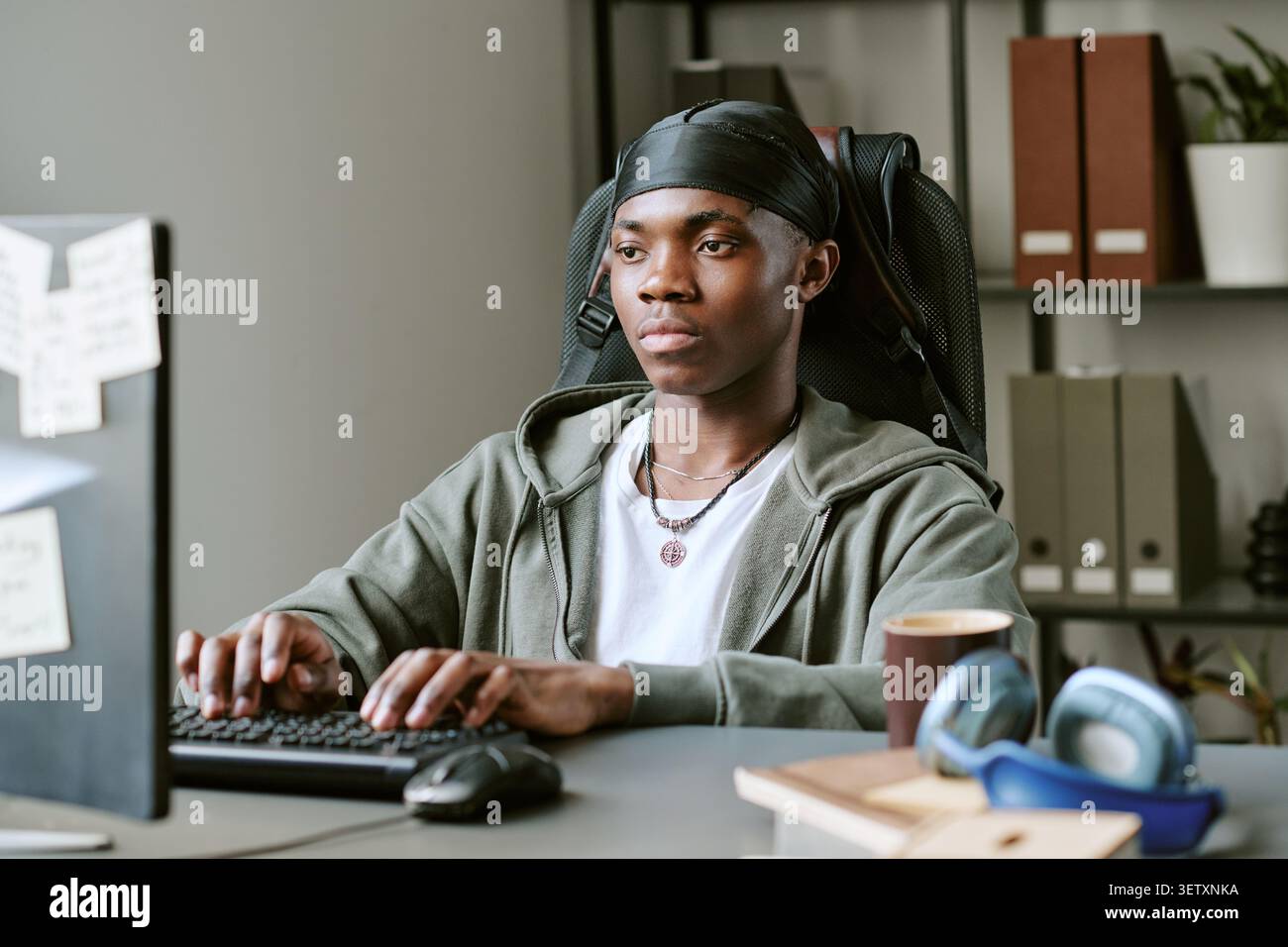 Black Man Working at Computer in Home Study Space Stock Photo