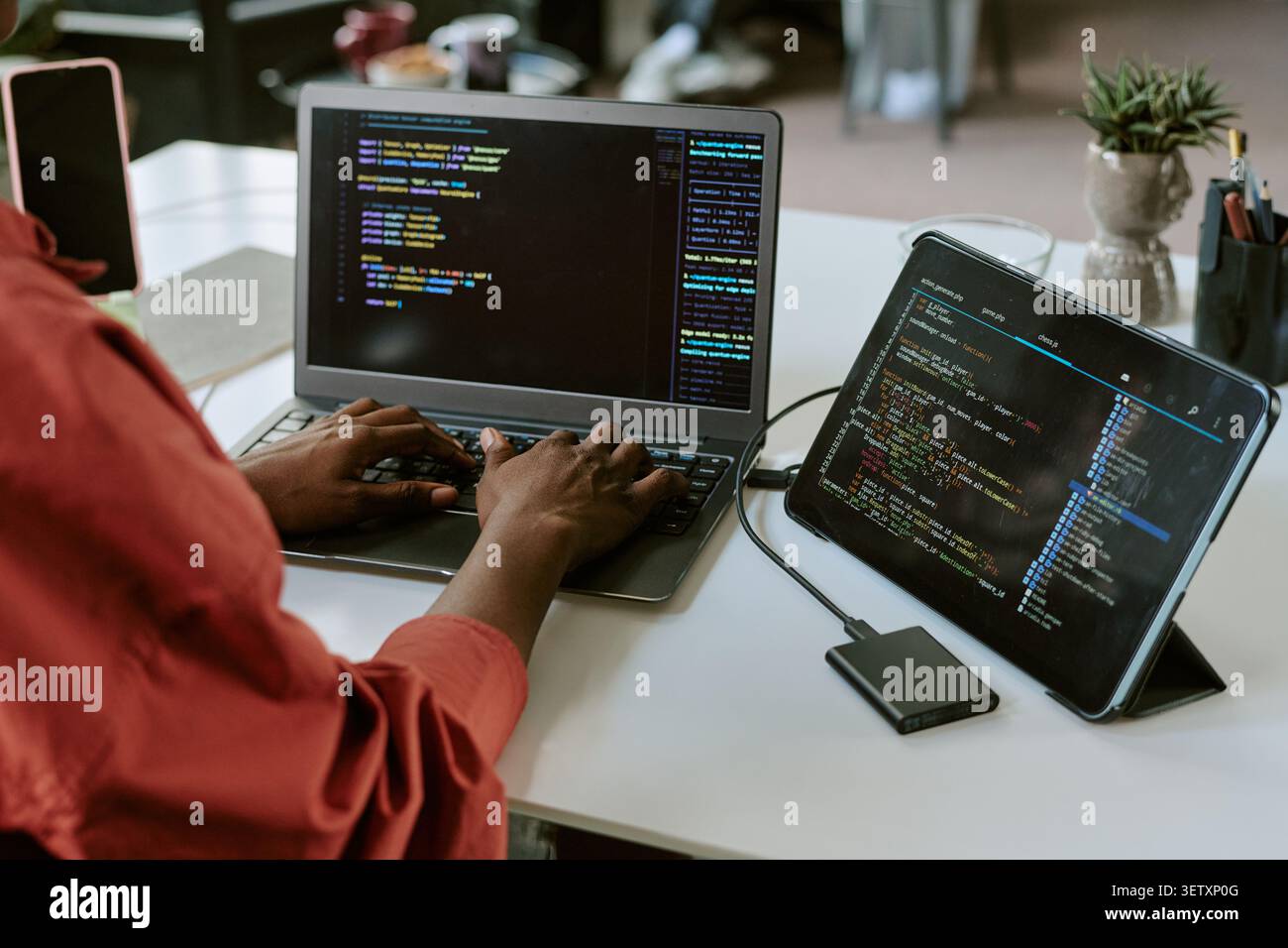 Black Woman Coding on Laptop and Tablet for Software Development Stock Photo