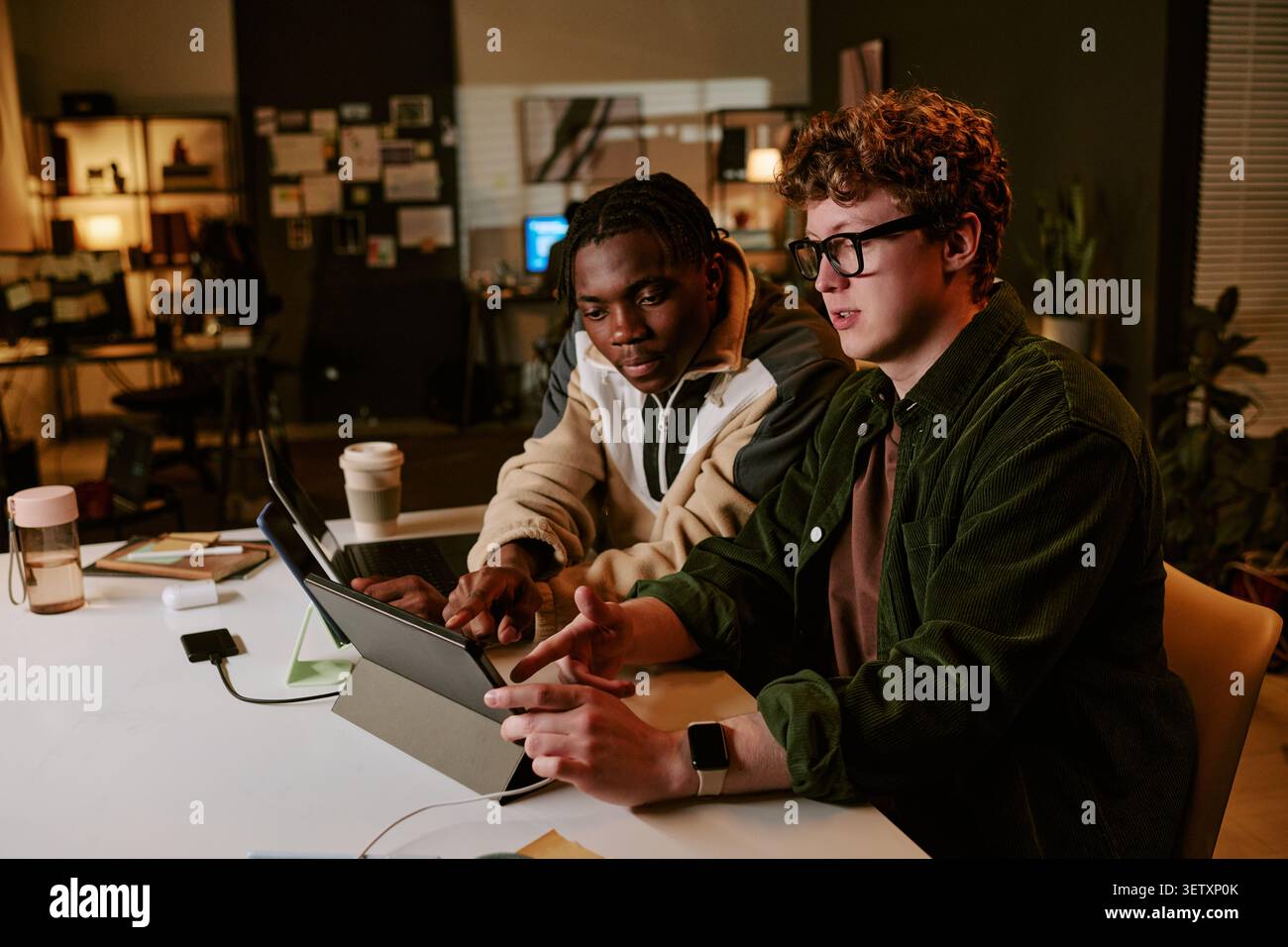 Workers Collaborating on Tablet for Digital Project Stock Photo