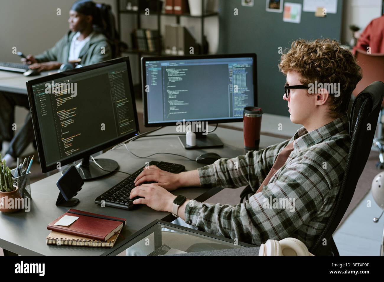 Caucasian Man Programming at Dual Monitors in Startup Office Stock Photo
