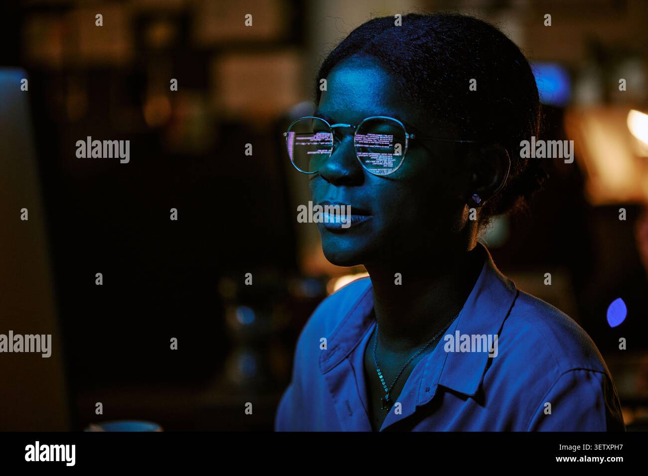 Black Woman Programmer Working Late on Cybersecurity Code Stock Photo