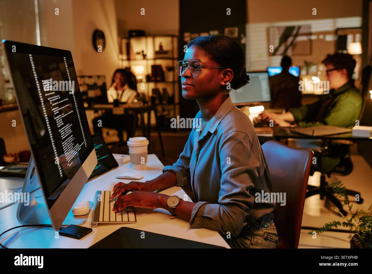 Black Woman Developer Coding at Computer in Modern Office Stock Photo