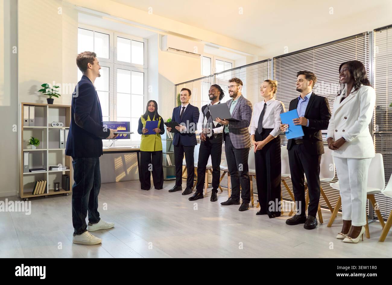 Presenter speaking to diverse office team, group listening during business meeting Stock Photo