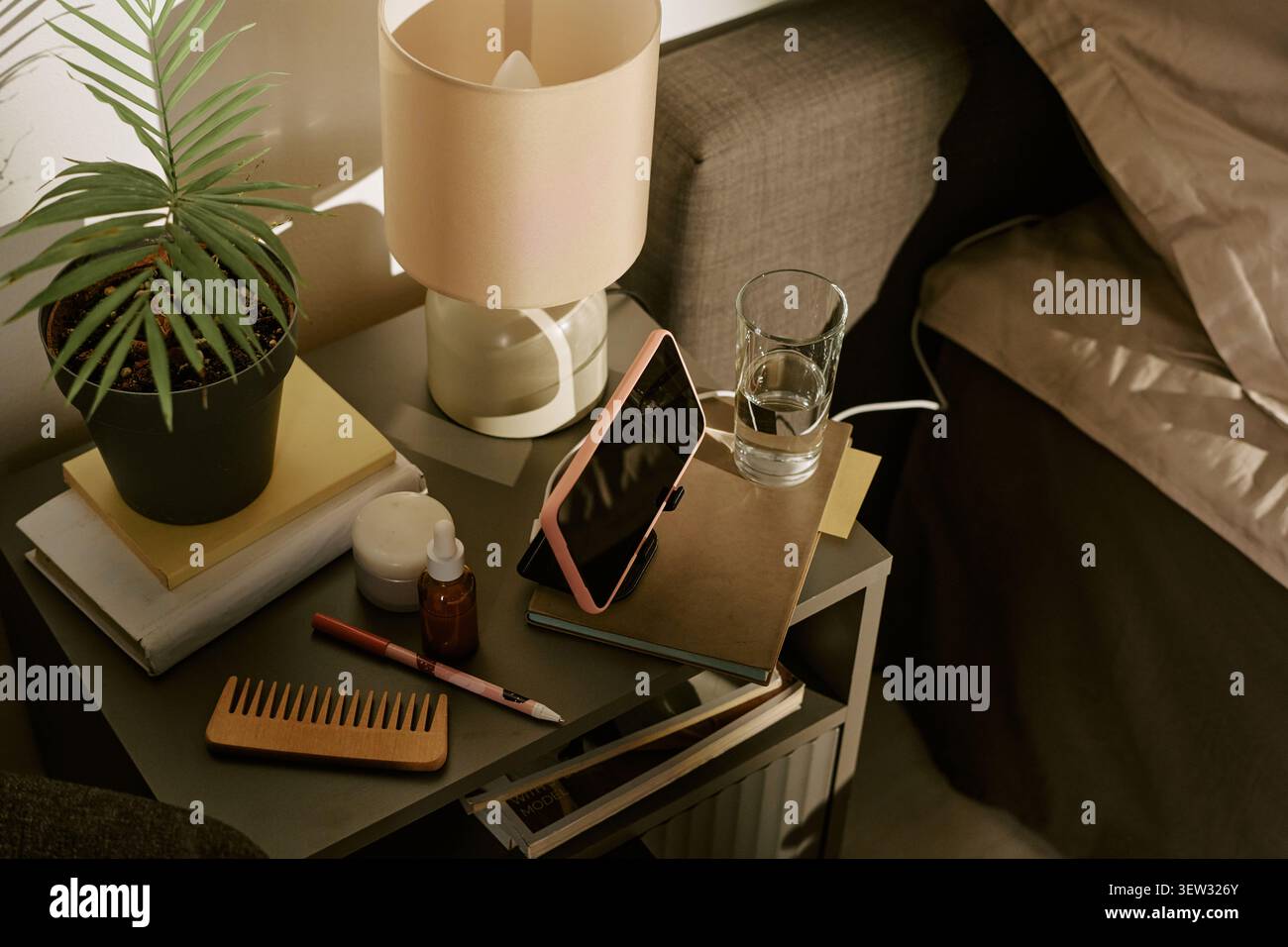 Smartphone Charging on Bedside Table for Evening Wellness Routine Stock Photo