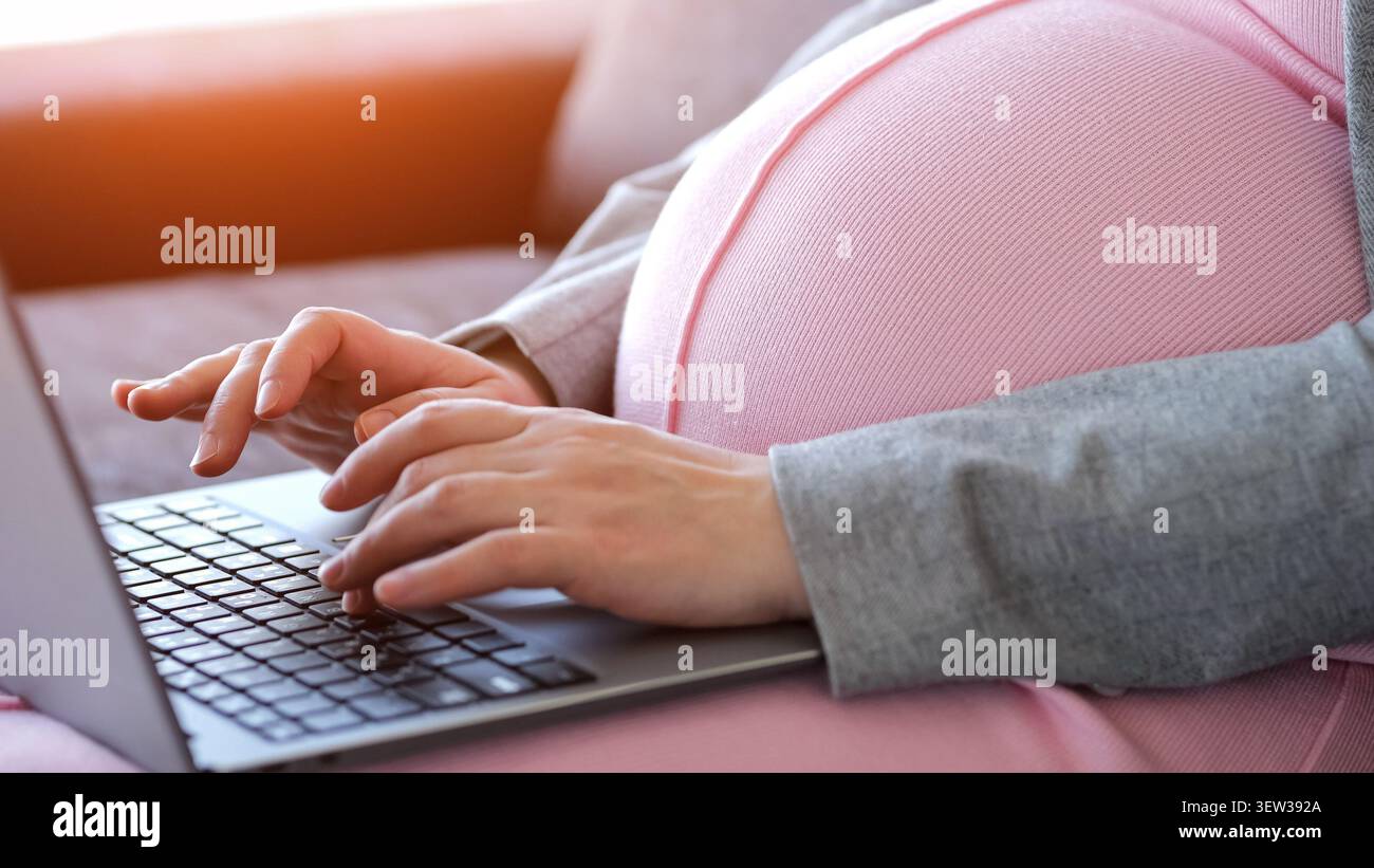 Pregnant woman remote working on laptop at home Stock Photo