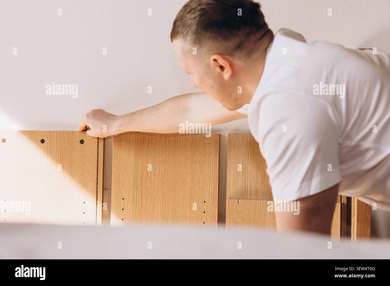 Man assembling flat pack furniture at home Stock Photo