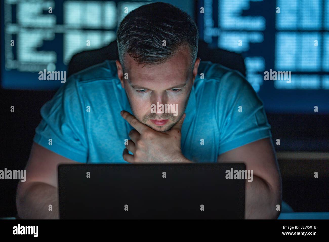 Programmer analyzes code in dark room. Programmer writes programming for secure software. Programmer monitors network and database. Programmer prevent Stock Photo