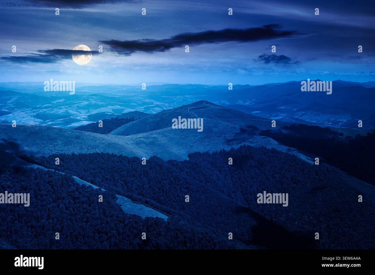 mysterious mountain landscape in summer at night. travel ukraine background. full moon over rolling hill in dappled light. scenic view of borzhava rid Stock Photo