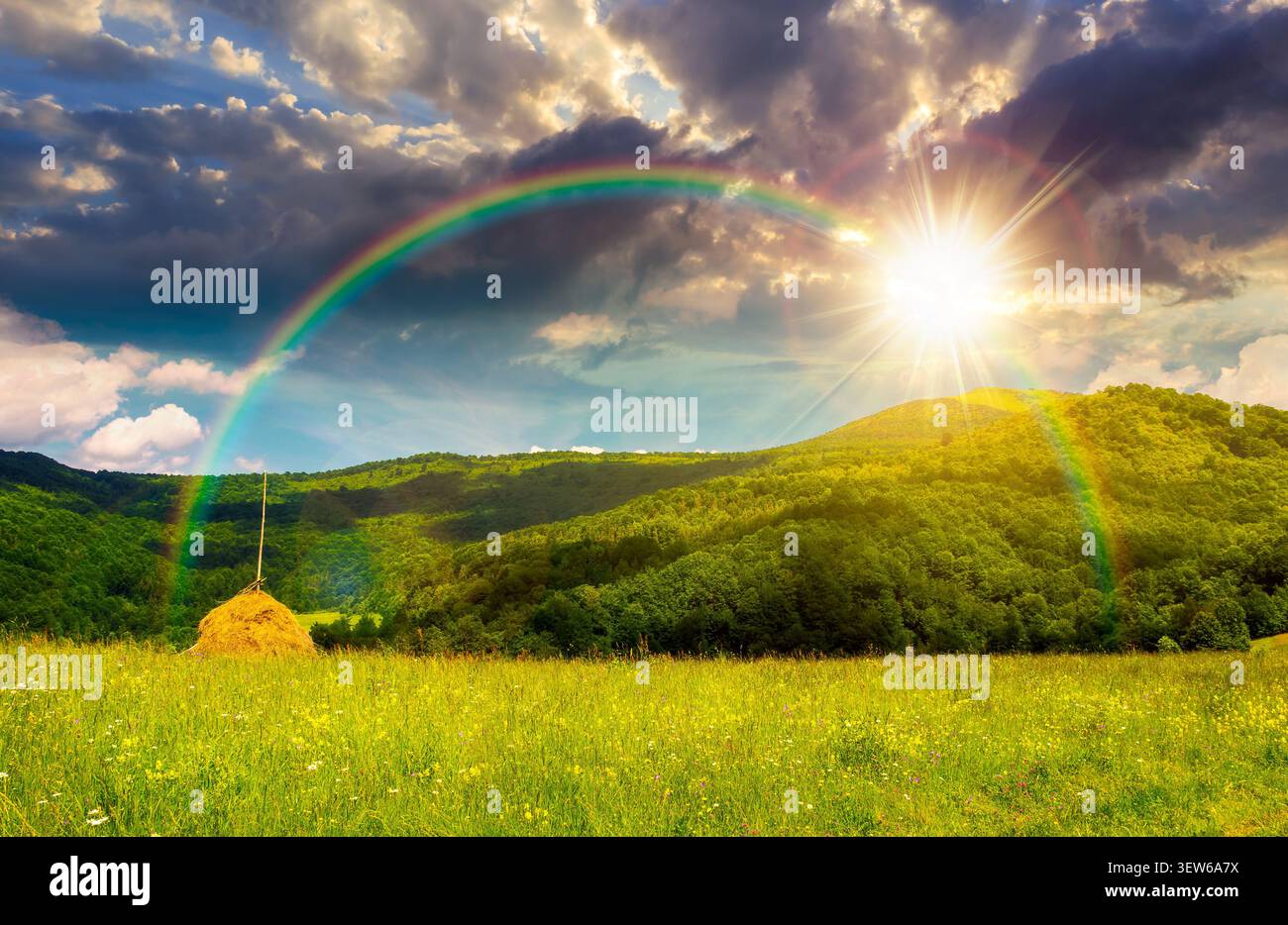 sunset over rural fields near pikui mountain in summertime. beautiful view of agricultural area. gorgeous mountain ridge with haystack on a grassy pas Stock Photo