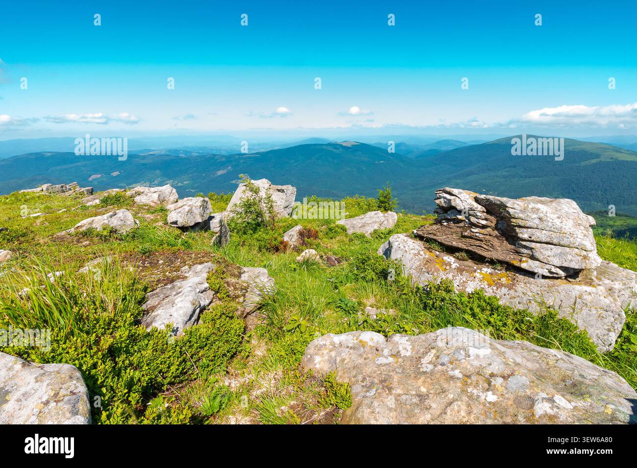 mountain landscape with stones and grass. view of carpthian mountains in summer. white sharp stones on the rolling hills on top of mountain range unde Stock Photo