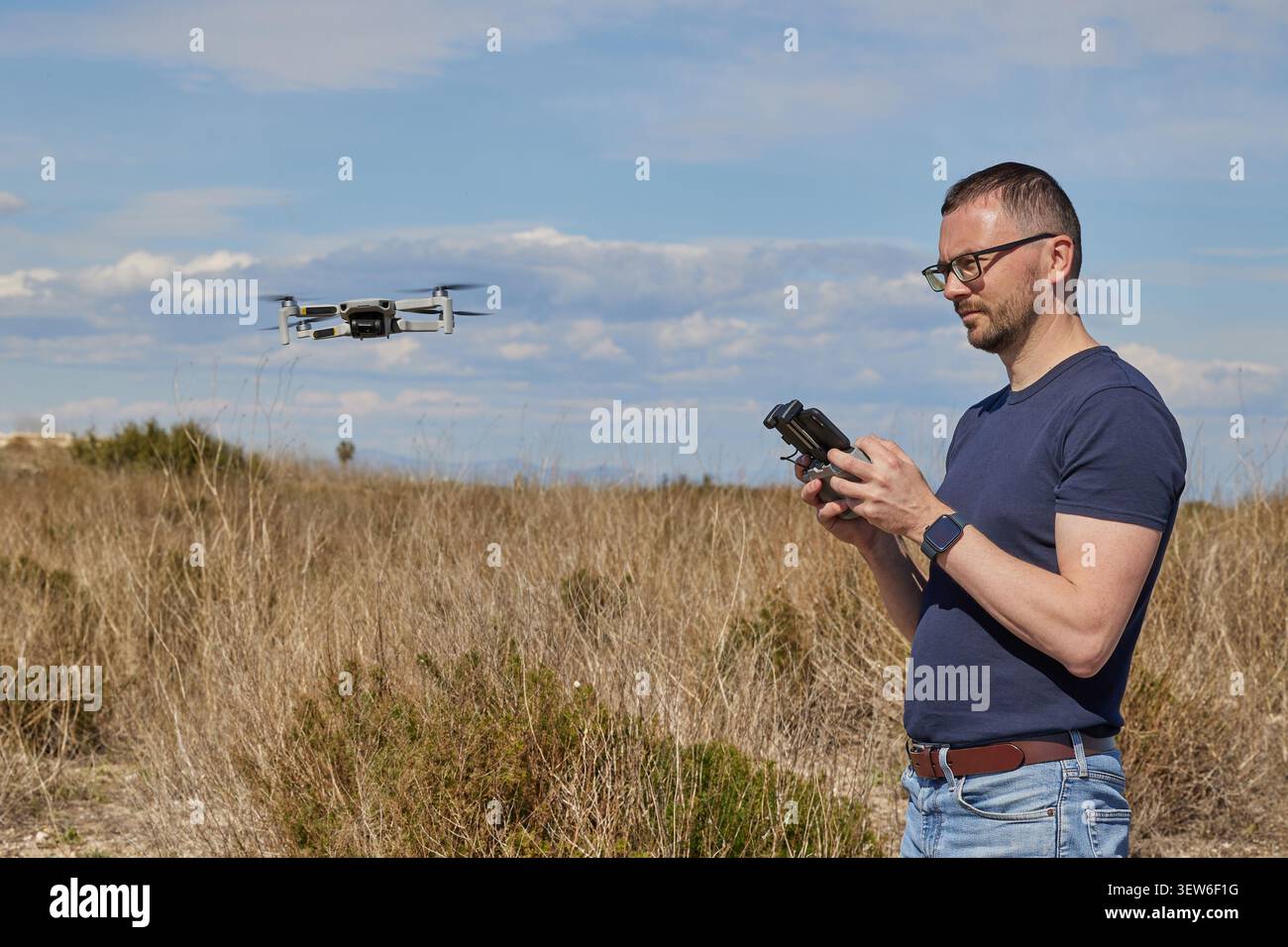 A handsome man controls a quadcopter in a field Stock Photo