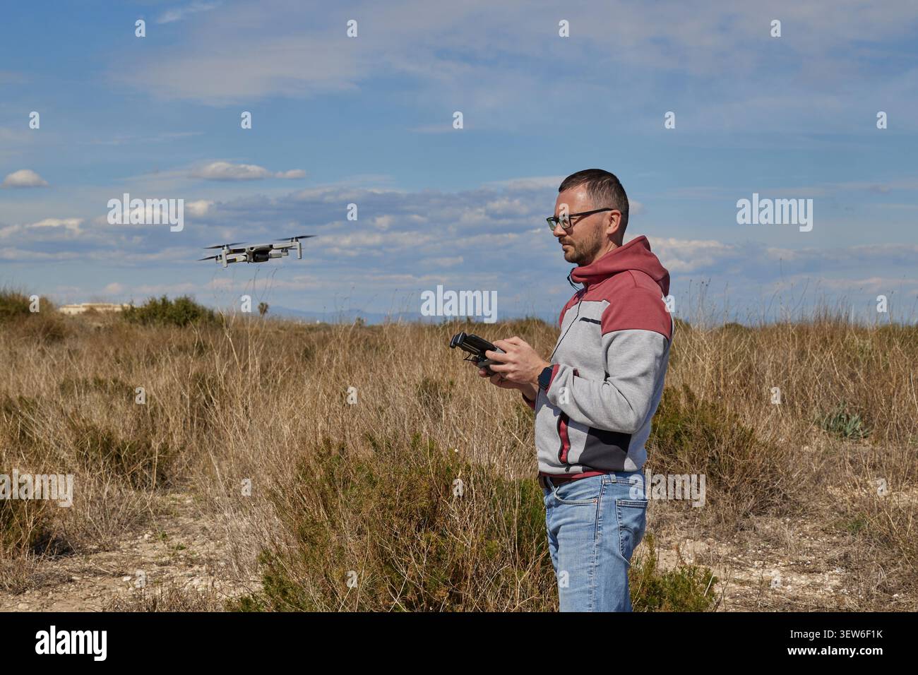 A handsome man controls a quadcopter in a field Stock Photo