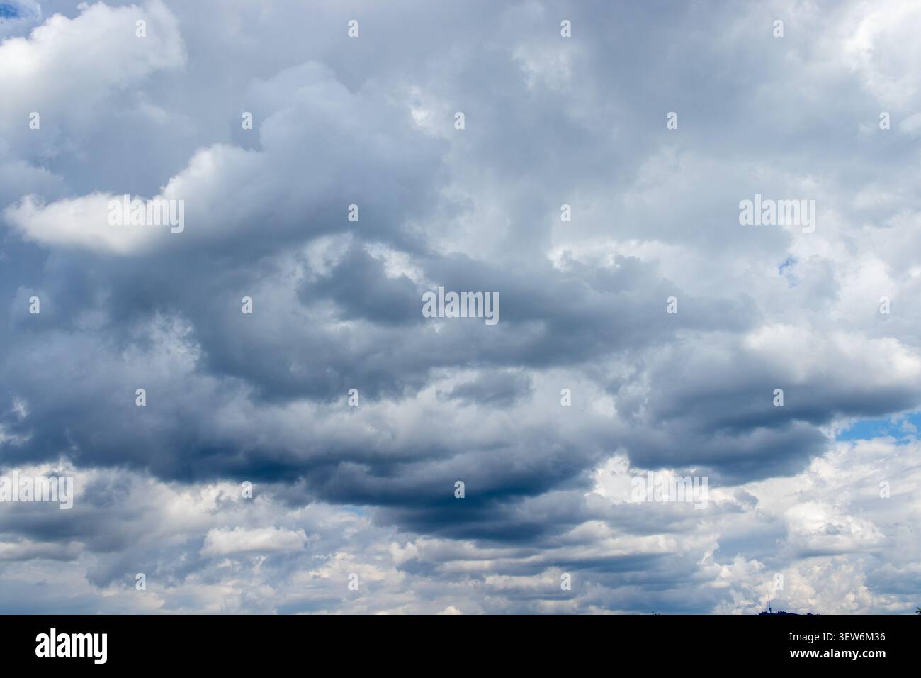 Dramatic Overcast Sky with Heavy Grey Clouds and Blue Patches Stock Photo