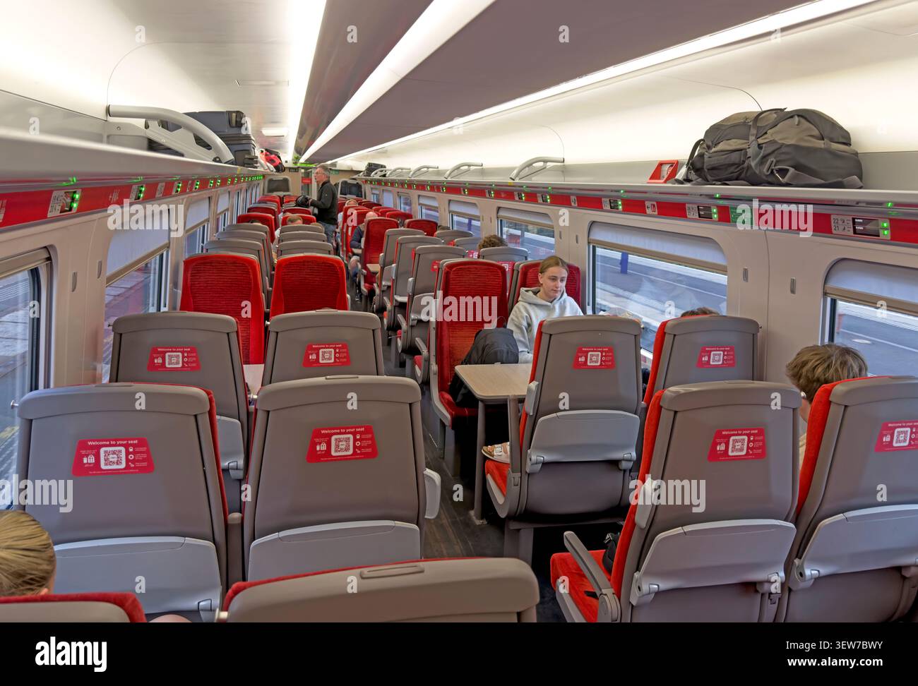 Passengers aboard an LNER Azuma Standard Class carriage travelling north from Edinburgh to Aberdeen on an evening service. Stock Photo
