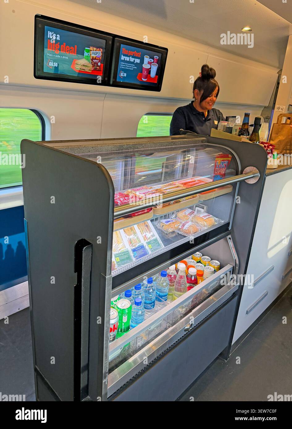 Avanti OnBoard shop,coach C,Catering employee staffing the Avanti West Coast onboard refreshment counter during an intercity journey through Lancaster Stock Photo