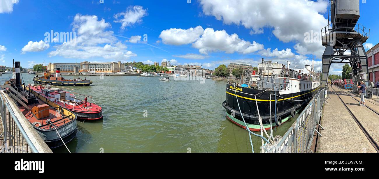 Wide panorama of Bristol Floating Harbour from Princes Wharf, with M Shed dockside crane and MV Balmoral on the waterfront,under blue sky Stock Photo